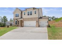 New two-story home with a two-car garage and brick and siding exterior on a green lawn at 7525 Homer Dr, Cumming, GA 30028
