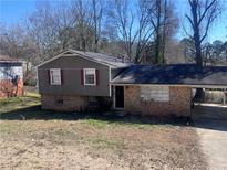 Charming split-level home with a brick facade, vinyl siding, and a covered carport at 5430 Old Bill Cook Rd, Atlanta, GA 30349