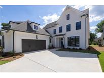 Beautiful two-story home with a dark gray two car garage and a well maintained front yard at 574 Sawnee Village Blvd, Cumming, GA 30040