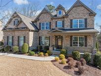 Stately brick home with manicured landscaping and inviting front porch at 4075 Winterberry Rd, Cumming, GA 30040