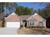 Charming brick home with a well-manicured lawn and an attached two-car garage at 1358 Apple Orchard Ln, Snellville, GA 30078