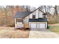 Charming two-story home with black and white accents and an attached two-car garage at 3817 Raiders Ridge Dr, Lithonia, GA 30038