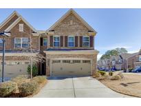 Charming brick townhome with a two-car garage and well-maintained landscaping in a desirable community at 1327 Lanier Vista Dr, Buford, GA 30518