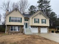Charming split-level home featuring stone accents, green shutters, and a well-manicured front yard at 3071 Hyacinth Dr, Austell, GA 30106