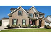 Elegant two-story brick home featuring a manicured lawn and a welcoming stone-accented entrance at 2903 Eva Clb, Acworth, GA 30101