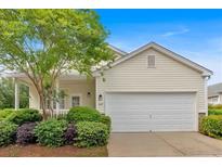 Charming home with a two-car garage and beautiful landscaping, including mature trees and lush bushes at 627 W Oaks Dr, Woodstock, GA 30188