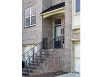 Charming brick townhouse entry featuring black iron railings and stairs leading up to the front door at 1992 Cobblestone Ne Cir, Brookhaven, GA 30319