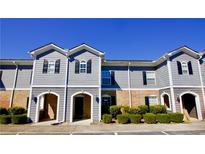 Charming townhouse with gray siding, brick accents, shutters and manicured landscaping at 506 Summer Pl, Norcross, GA 30071