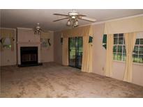 Spacious living room with a fireplace, ceiling fan, and sliding glass doors to the backyard at 3204 Spreading Oak Sw Dr, Atlanta, GA 30311