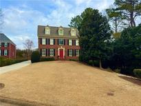 Charming two-story brick home with a well-manicured lawn and a bright red front door at 4045 Boles Creek Dr, Duluth, GA 30096