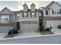 Traditional two-story townhouse featuring a two-car garage and manicured landscaping at 5008 Whiteoak Pointe Se # 15, Smyrna, GA 30080