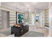 Elegant entryway featuring striped walls, a mirrored wall, dark console table, and artwork at 750 Park Ne Ave # 25W, Atlanta, GA 30326
