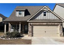 Charming home with a brick facade, two-car garage, and well-manicured landscaping at 2190 Bridgewater Pass, Hampton, GA 30228