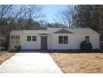 Charming single-story home with a well-manicured front yard and a freshly paved concrete driveway at 2568 Loghaven Nw Dr, Atlanta, GA 30318