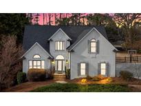 Charming home with elegant gray shutters, manicured lawn, and brick steps leading to an arched entryway at 5382 Whitaker Nw Trl, Acworth, GA 30101