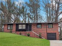 Charming red brick single-story home with well-maintained lawn and inviting curb appeal at 3230 Jamaica Nw Rd, Atlanta, GA 30318