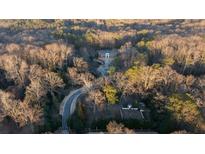 A beautiful home with circular driveway sits nestled amongst lush foliage in a private wooded lot at 4615 Northside Dr, Atlanta, GA 30327