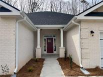 Charming front entrance features a brick facade, stylish columns, and a striking red door at 5311 Tuscany Drive, Douglasville, GA 30135