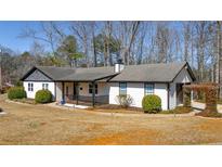 Charming single-story home features a inviting front porch, well-maintained landscaping, and mature trees at 360 Chimney Ct, Fairburn, GA 30213