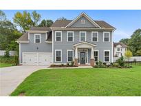 Charming two-story home with a manicured lawn and a two-car garage at 3790 Chattahoochee Rd, Cumming, GA 30041