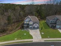 Beautifully landscaped home with a well-manicured lawn and a wooded backdrop at 372 Garnet Dr, Acworth, GA 30101