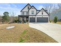 Charming two-story home featuring a two-car garage, well-manicured lawn, and a welcoming front porch at 372 Garnet Dr, Acworth, GA 30101