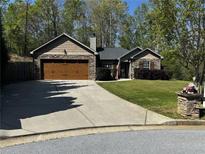 Charming single-story home with stone and wood accents, lush landscaping, and a two-car garage at 101 Flagler Way, Dallas, GA 30157
