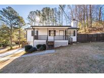 Charming home featuring a quaint front porch with beautiful wood railing and landscaped yard at 2571 Hamill Dr, Buford, GA 30519