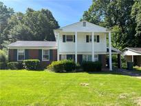 Two-story home with a manicured lawn, brick accents, large windows, and decorative green shutters at 2900 Eleanor Nw Ter, Atlanta, GA 30318