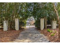 Wrought iron gate with stone pillars at the entrance to the tree-lined driveway at 5323 Presley Pl, Douglasville, GA 30135