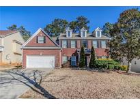 Charming two-story brick home featuring a two-car garage,dormers, and a beautifully landscaped front yard at 1011 Buckhorn Bnd, Locust Grove, GA 30248