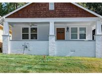 Charming home featuring a covered front porch, white brick foundation, and updated windows at 1575 Montreat Pl, Atlanta, GA 30311