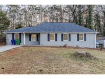 Charming single-story home features gray paint, black shutters, and mature trees at 554 Sherwood Oaks Rd, Stone Mountain, GA 30087