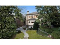 Elegant home featuring a manicured front lawn with lush landscaping and a charming stone walkway at 81 Peachtree Ne Cir, Atlanta, GA 30309