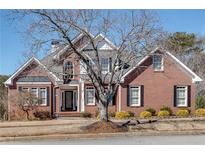 Charming two-story brick home featuring a classic design and well-manicured front yard at 1279 Saxony Se Dr, Conyers, GA 30013