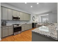 Modern kitchen with granite countertops, stainless steel appliances, and stylish tile backsplash at 1286 Creekside Se Ter, Smyrna, GA 30082