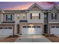 Charming townhome with a two-car garage and brick and siding exterior at 1026 King Iron Dr, Lawrenceville, GA 30045