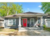 Charming gray bungalow with a welcoming front porch, red door, and well-manicured landscaping at 2599 Church Nw St, Atlanta, GA 30318