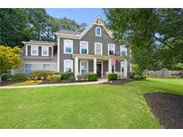 Charming two-story home with manicured lawn, inviting front porch, and a mix of brick and siding accents at 3460 Trow Creek Ln, Cumming, GA 30040