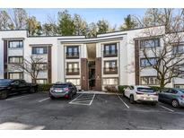 Modern condo building with parking in front and mature trees surrounding the property at 1445 Monroe Ne Dr # F12, Atlanta, GA 30324