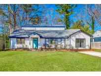 Charming bungalow with painted brick, blue trim, bright blue front door, and a well-maintained lawn at 1218 Crestwood Se Dr, Atlanta, GA 30316