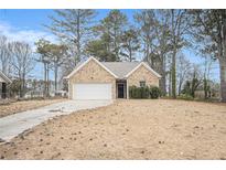 Charming one-story home with brick facade, a driveway, and an attached garage at 5068 Paris Ave, Powder Springs, GA 30127