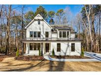 Charming two-story home featuring board and batten siding, a metal roof, and a covered front porch at 1977 Westwood Se Cir, Smyrna, GA 30080