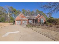 Charming brick home featuring a two-car garage, well-manicured landscaping, and a welcoming entrance at 1460 Badingham Dr, Cumming, GA 30041