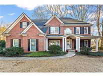 Beautiful brick two-story home with a well-manicured lawn and inviting front porch at 607 Crimsonwood Ct, Powder Springs, GA 30127