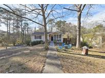 Cozy single-Gathering home featuring a welcoming front yard and a charming porch area with chairs at 4196 Rocky Face Dr, Douglasville, GA 30135