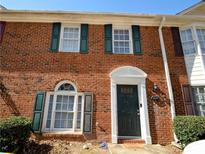 Charming brick townhouse with dark green shutters and a well-maintained front entrance at 5647 Executive Way, Norcross, GA 30071