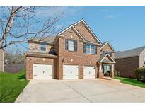 Traditional brick home showcasing a three-car garage and well-maintained lawn at 1263 Polk Xing, Mcdonough, GA 30252
