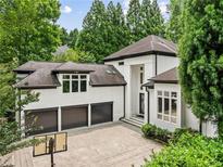 Stunning home exterior with a three-car garage, basketball hoop and beautiful landscaping at 4000 Wieuca Ne Rd, Atlanta, GA 30342