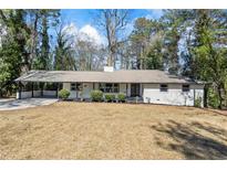 Charming single-story home with a light gray facade, well-manicured shrubs, and an attached carport at 4425 Cascade Sw Rd, Atlanta, GA 30331